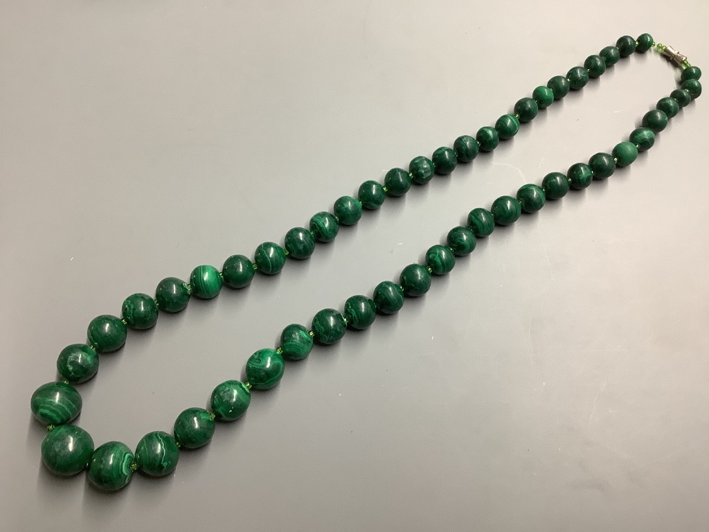 A malachite necklace, three other necklaces and two bracelets.